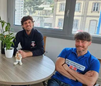 Due odontoiatri dello staff, seduti a un tavolo nell'ambulatorio
